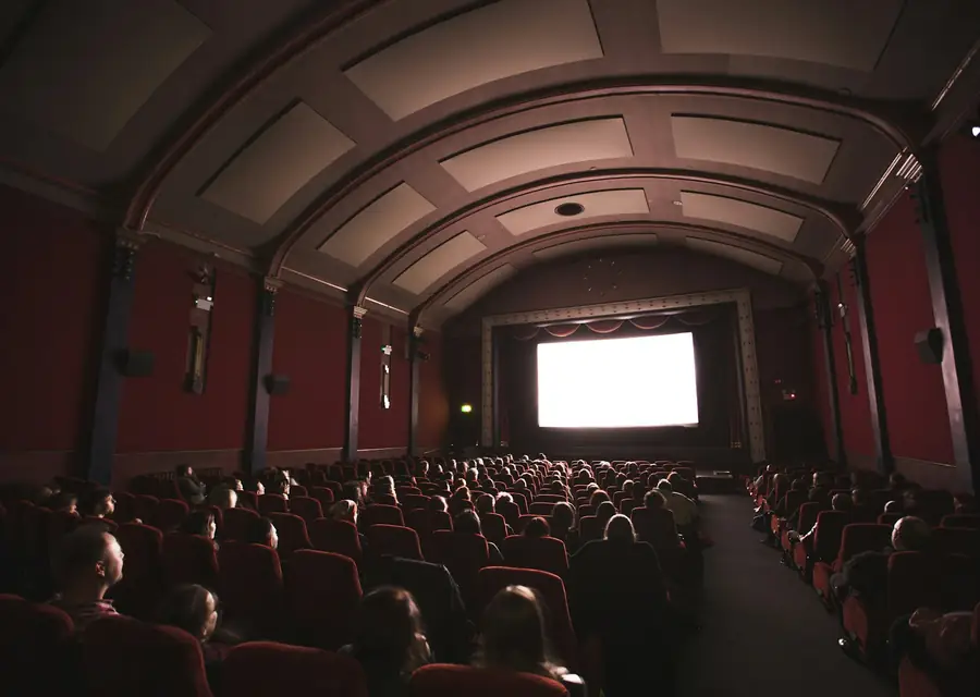 صالة سينما مظلمة أمام شاشة مضاءة